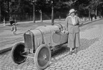Violette Morris en 1922, en tenue féminine, pose aux côtés d'une automobile Benjamin.